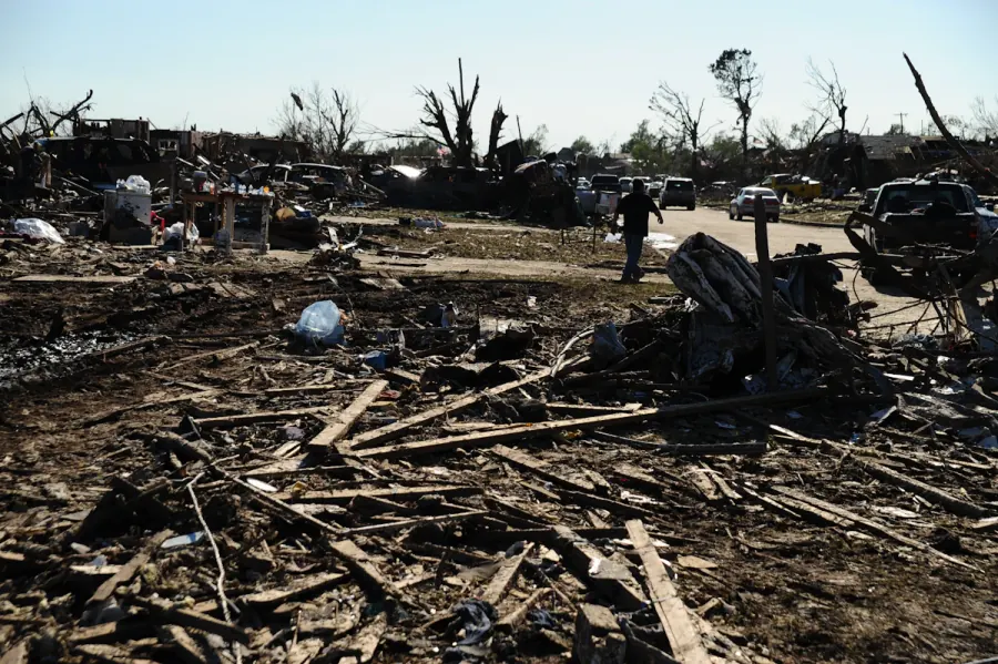 Storm-damaged debris and wrecked building material piled outside a house after a hurricane